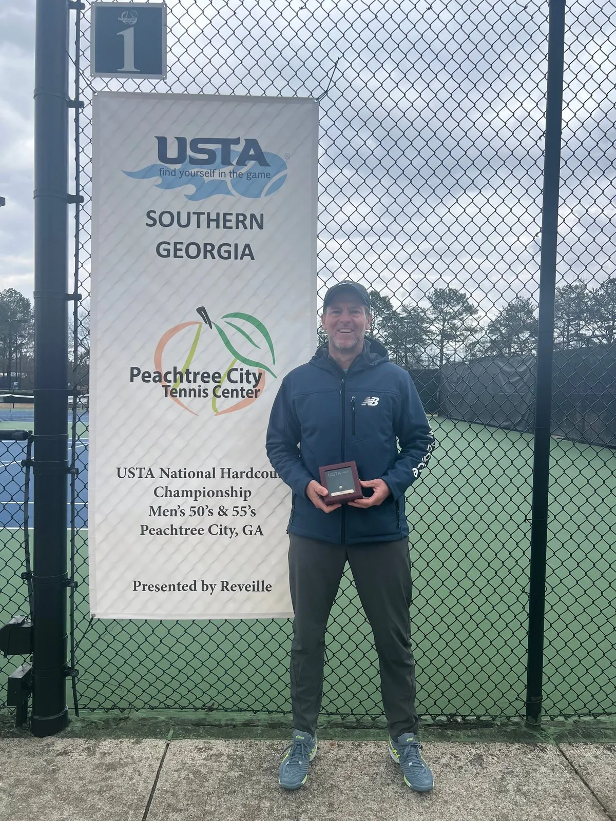 Pontus with his award beside the USTA National Hardcourt Championship banner in Peachtree City, Georgia